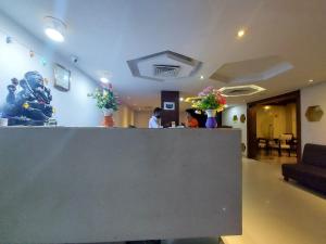 a lobby with a bar with people sitting at a table at Orbit Hotel - Bagdogra in Bāghdogra