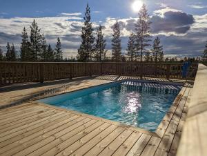 a swimming pool on a deck with a wooden deck at Poolorama Lodge - with magnificent mountain view in Idre