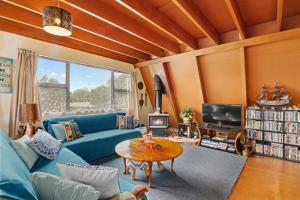 a living room with a blue couch and a table at Pohara Retreat - Pohara Holiday Home in Pohara