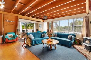 a living room with blue couches and a table at Pohara Retreat - Pohara Holiday Home in Pohara