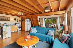 a living room with a blue couch and a table at Pohara Retreat - Pohara Holiday Home in Pohara