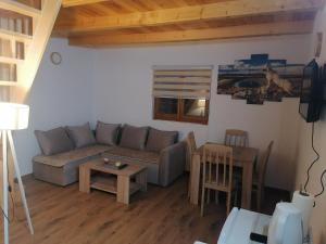 a living room with a couch and a table at BUNGALOVI TIM in Žabljak