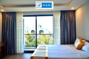 a bedroom with a large bed with a large window at HANZ Sang Sang Hotel in Phu Quoc