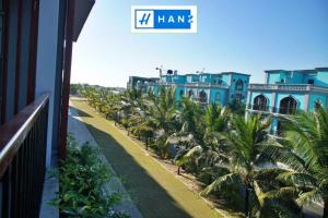una fila di palme davanti a un edificio di S79 Happy Hana Hotel Phu Quoc a Phu Quoc