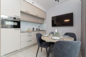 een keuken met een tafel en stoelen bij Mielno Sea & Lake Apartment by Renters in Mielno