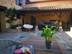 a wooden table with a hammock on a patio at La Mirabelle des 3 Forêts in Bricon