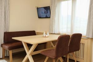 mesa de comedor con 2 sillas y TV en Rosspointnerhof, en Haus im Ennstal