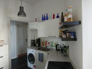eine Küche mit einer Spüle und einer Waschmaschine in der Unterkunft Ferienwohnung Dahme Berlin am Wasser in Berlin