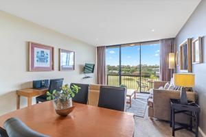 a room with a table and chairs and a living room at Fairway Views – Moonah Apartment 23 & 24 in Fingal