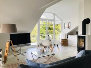 En tv och/eller ett underhållningssystem på moderne Ferienwohnung mit Balkon, Meerblick - Ferienresidenz Zwei BoddenFeWo 1-5