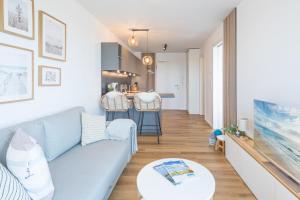 - un salon avec un canapé bleu et une table dans l'établissement Apartment N14 direkt am Nordseedeich mit Blick auf den See, à Nordstrand