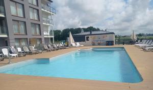 a large swimming pool in front of a building at Apartamenty z basenem in Sarbinowo