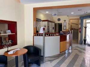 a waiting room with a counter and a table at Tisza Alfa Hotel in Szeged