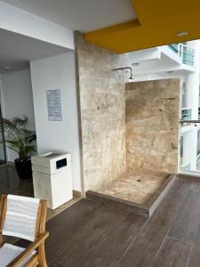 a room with a shower with a stone wall at Luxury condo en Malecón, Alberca Infinity & Jacuzzi in Mazatlán