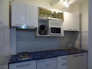 a kitchen with white cabinets and a sink and a microwave at LVC,LAC & NYC Apartshotel Faleza in Galaţi