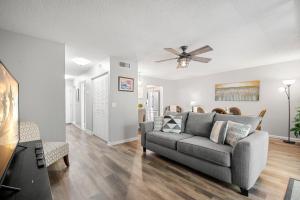 Una sala de estar con un sofá y un ventilador de techo. en Seashell 19, en Clearwater Beach