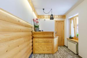 a home office with a wooden wall and a desk at Gościna u Maryny in Poronin