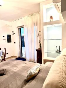 een slaapkamer met een bed en een groot raam bij Villa Petra Sappa - RELAX & WELLNESS in Acireale