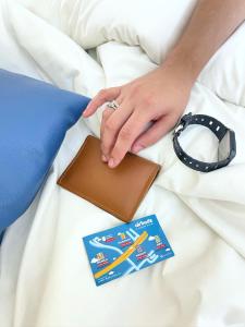 a person with a wallet and a book on a bed at airobedz MANILA - near Taft Avenue in Manila