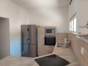 a kitchen with a stainless steel refrigerator and a sink at Apartments Dora, with a beautiful view of the bay, near the sea and center in Vrboska