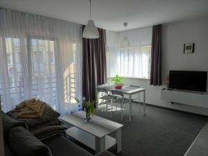 uma sala de estar com um sofá e uma mesa em Apartamenty Słoneczna Przystań em Łeba