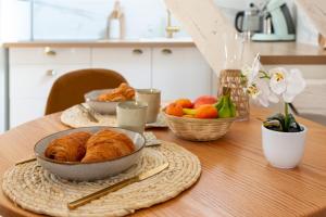 a table topped with a bowl of croissants and fruit at Cosy Chambord à 10 minutes du château in Mont-près-Chambord