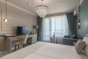 ein Hotelzimmer mit einem Bett und einem Schreibtisch mit einem Fernseher in der Unterkunft Aquamarine - Beach & SPA Hotel- All inclusive in Kranewo