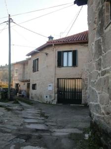 una antigua casa de piedra con una puerta y un edificio en Casa da Vilaboa, Allariz, en Allariz