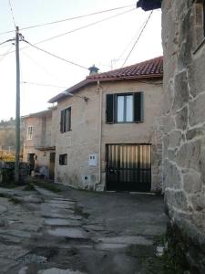 an old stone house with a gate and a building at Casa da Vilaboa, Allariz in Allariz