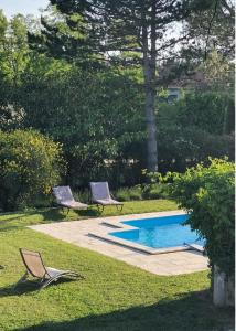 2 sillas y una piscina en un patio en La Maison Verte, en Tulette