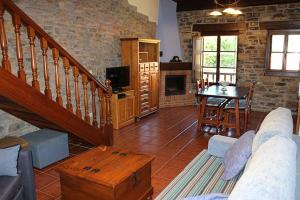 a living room with a couch and a tv and a fireplace at Rodiles Rural Apartamentos in Selorio
