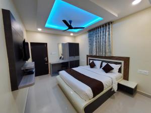 a bedroom with a large bed with a ceiling fan at Kings Palace in Chennai
