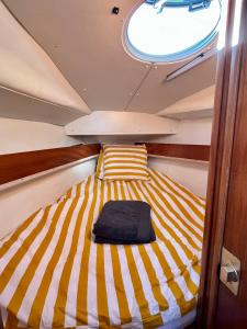 un lit à l'arrière d'un bateau dans l'établissement Matahari - Bateau cocooning à quai, à Les Sables-dʼOlonne