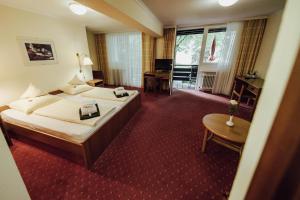 ein Hotelzimmer mit einem großen Bett und einem Schreibtisch in der Unterkunft Hotel Summerhof in Bad Griesbach + 7 Fotos