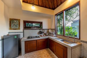 a kitchen with a sink and a window at Villa Natha in Ubud