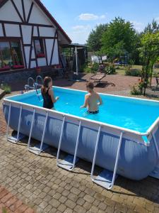 a couple of people in a swimming pool at Apartamentypomorze in Białogóra