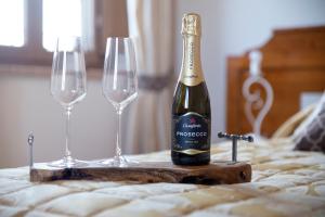een fles champagne en twee glazen op een bed bij Agriturismo Il Dolce Vivere in Quarrata