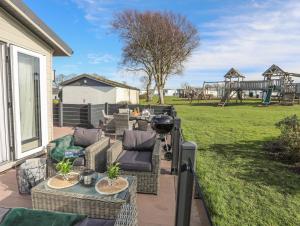 a patio with couches and tables and a playground at 97 Crugan in Pwllheli