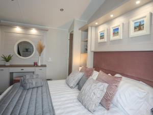 a bedroom with a large white bed with pillows at 97 Crugan in Pwllheli