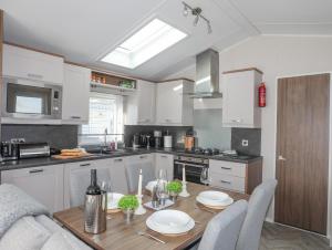 a kitchen with a wooden table with plates on it at 97 Crugan in Pwllheli