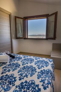 - une chambre avec un lit bleu et blanc et une fenêtre dans l'établissement L'Incanto di Mozia, à Marsala