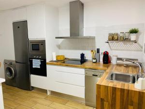 a kitchen with a sink and a stove at La casita de Lú in Casares