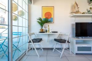 a room with a desk and chairs and a tv at Sofia's Cosy Studio in Larnaca in Larnaka