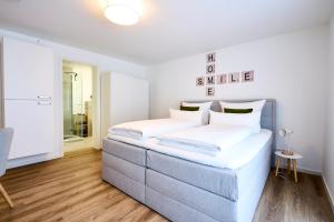 a bedroom with a large bed with white sheets at Modernes Apartment *Liobablick Nr. 5* - FeWo in Fulda/Petersberg in Petersberg +10 photos