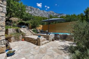 un patio con sombrilla y piscina en Olive Garden, en Makarska
