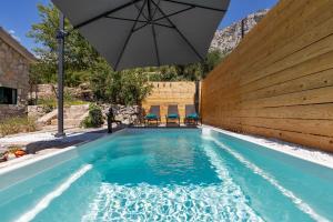 una piscina con sombrilla y una piscina en Olive Garden, en Makarska