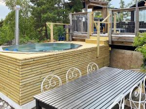 a hot tub on a deck with a table and a bench at 4 person holiday home in KERSBERGA in Åkersberga