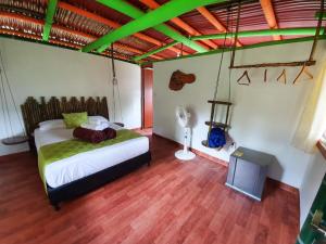 um quarto com uma cama e uma televisão em Room in Lodge - Glamping Cabin em Rizaralda