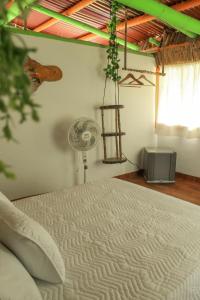 a bedroom with a white bed and a fan at Room in Lodge - Glamping Cabin in Rizaralda