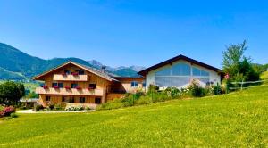 a house on a hill with a green field at KAINZLEITENHOF am Traunsee in Nachdemsee
